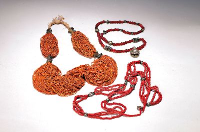 Drei Ketten, Afrika/Afghanistan, 20. Jh., eine Kette mit vielen Strängen mit kl. gelb-orangefarbenen Perlchen, Metalleinsätze L. ca. 80 cm, ...
