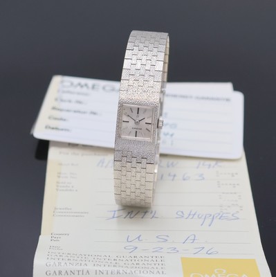 OMEGA Damenarmbanduhr in WG 585/000, Schweiz verk. lt. beil. Garantie 09/1976, Handaufzug, orig. Goldband, Boden aufgedr., silb. Zifferbl. m. aufges. ...