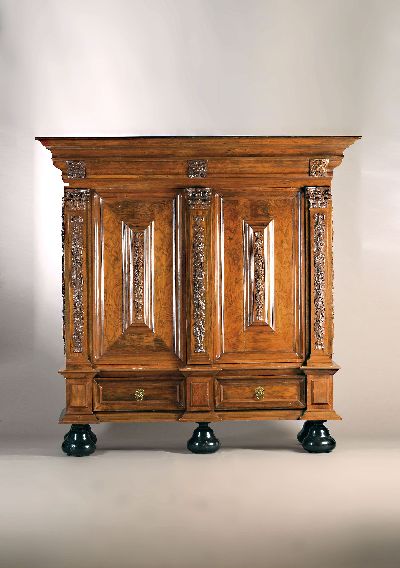 Pilasterschrank, Niederlande, Ende 18./19. Jh., Nussbaumfurnier, z.T. massiv, aufgelegte Schnitzereien auf der Front, den aufgesetzten Kissen und den ...