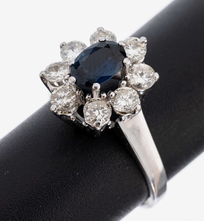 14 kt Gold Saphir-Brillant-Ring, WG 585/000, mittig erhaben gefasster ovalfacett. Saphir ca. 1.0 ct, umgeben von 8 Brillanten zus. ca. 1.20 ct ...