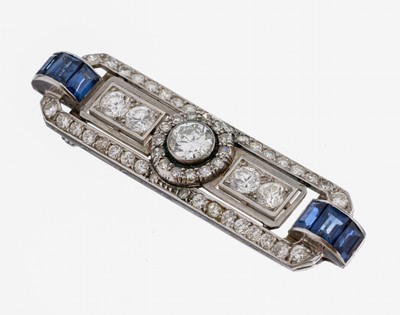 18 kt Gold Art Deco Diamant-Saphir-Brosche, um1930, WG 750/000 gepr., mittig Altschliffdiamant ca. 0.75 ct Weiß/p, seitl. 4Brillanten zus. ca. 1.0 ...