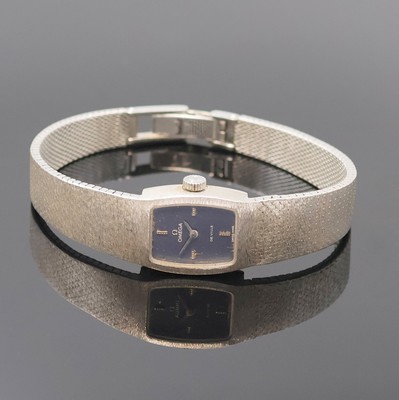 OMEGA De Ville Damenarmbanduhr in WG 750/000, Schweiz um 1969, Handaufzug, orig. Goldband, Boden aufgedr., dunkelblaues Zifferbl. pat./fl., 4 aufgel. ...