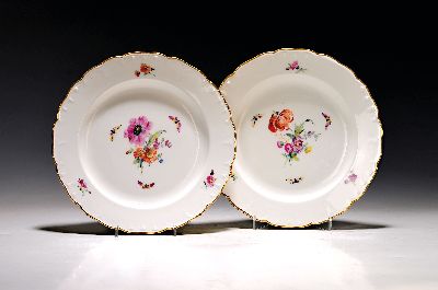 2 Teller, KPM Berlin, 20. Jh., Porzellan, fein bunt bemalt mit Blumen, gestreuten Blumen und Schmetterlingen, Goldränder, D. je ca. 25 cm