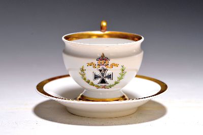 Tasse mit Untertasse, KPM Berlin, um 1914-18, Porzellan, bunt bemalt mit Eisernem Kreuz, Eichen- und Lorbeerkranz, breite Goldränder, auf der ...