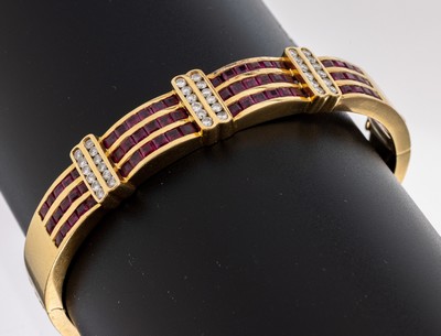 18 kt Gold Rubin-Brillant-Armreif, GG 750/ 000 gefüllt, 66 Rubin-Carrees zus. ca. 2.58 ct, 36 Brillanten zus. ca. 0.47 ct Weiß/si, D.ca. 5.8 x 4.8 ...
