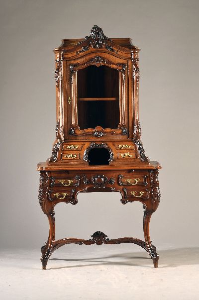 Sekretär/Kabinettschrank, wohl Mainz, um 1860, Nußbaumfurnier z.T. massiv, Unterteil als Schreibtisch mit Schubladen, aufwendig geschnitzt Oberteil ...