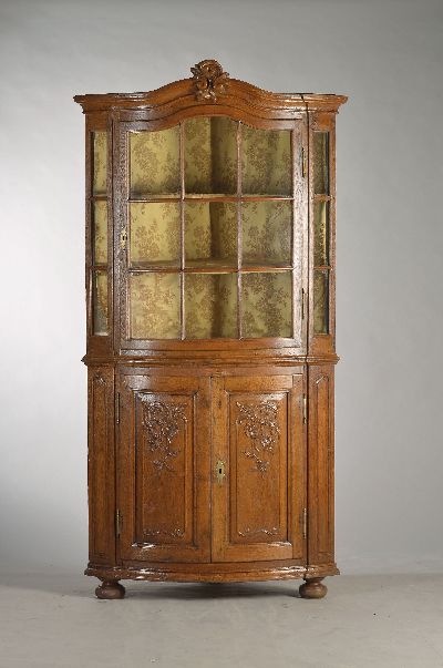 Barock-Eckvitrine, um 1760, Eiche massiv, zweitürig, Unterteil kassettiert, aufwendige florale Reliefschnitzereien, Oberteil mit Glastür, insgesamt ...
