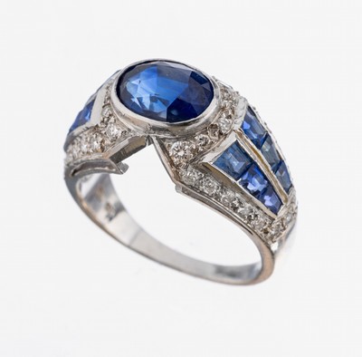18 kt Gold Saphir-Brillant-Ring, WG 750/000, mittig ovalfacett. Saphir von schönerFarbe ca. 2.00 ct (wohl beh.), 12 eingeschliffene Saphire zus. ...