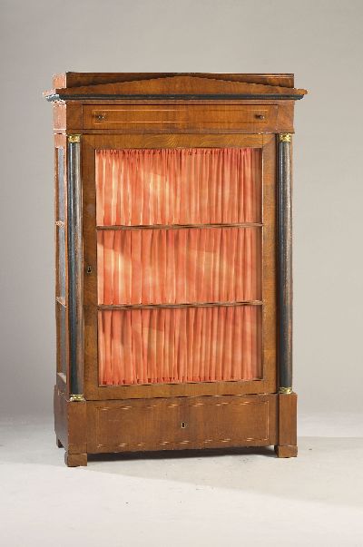 Spätklassizistische Vitrine, um 1820, Nußbaumfurnier, eintürig, mehrfach verglast, mit geschwärzten Säulen, innen verspiegelt, 2 Schubladen, ca. ...
