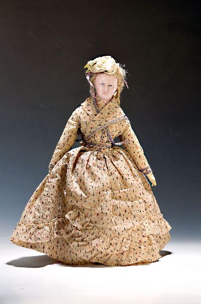 Wachskopfpuppe, wohl englisch, um 1880/90, strohgefüllter Gliederkopus aus Stoff, Kleid, Hut und Schuhe der Zeit, Echthaar, Gesicht bestoßen, H. 46 ...