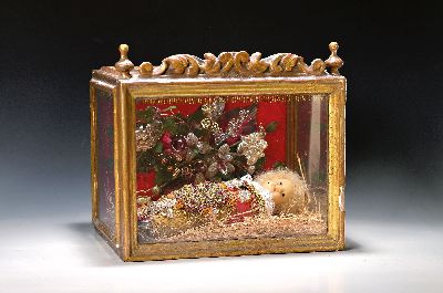 Fatschenkind in Schauvitrine, alpenländisch, 19.Jh., auf Stroh gebettete Wachskopfpuppe, aufwendig gefatscht mit Seide, Golddraht, Bouillon und ...
