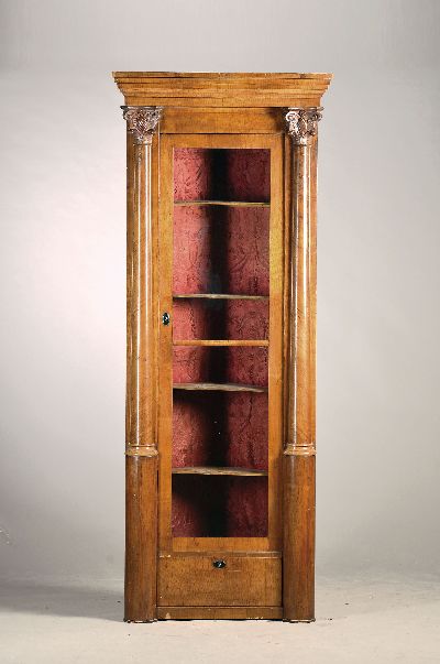 Große Eckvitrine, 19.Jh., Nußbaum, eintürig verglast, Sockel mit Schublade, Front mit Halbsäulen und geschnitzten Kapitellen, ca. 232 x 92 cm, EZ ...