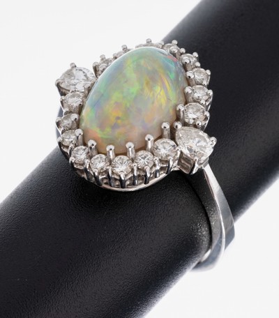 18 kt Gold Opal-Diamant-Ring, WG 750/000, mittig ovaler Opal-Cabochon ca. 6.0 ct, Farbspiel in Blau und Grün, 2 facett. Diamanttropfen und 16 ...