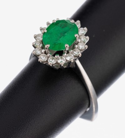 18 kt Gold Farbstein-Brillant-Ring, WG 750/000, mittig erhaben gefasste ovalfacett. Smaragdtriplette, 16 Brillanten zus. ca. 0.45 ct Weiß/si, RW ...
