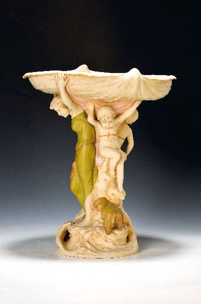 Aufsatzschale, Royal Dux, Anfang 20.Jh., Keramik, farbig bemalt, Schale in Muschelform, getragen von einer Kanephore und zwei Putti im Duktus der ...