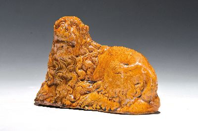 Steinzeugfigur, wohl 17. Jh., liegender Löwe mit gelockter Mähne, ockerfarbene Glasur, hohl, gemodelt, alterbed. berieben und glasurrissig, im ...
