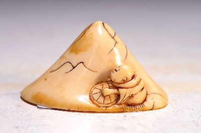 Netsuke, Japan, späte Edo-Zeit bzw. 1.Hälfte 19.Jh., Elfenbein geschnitzt, Darstellung eines Mannes am Fuße eines Berges, H. 2,7 cm; mit ...