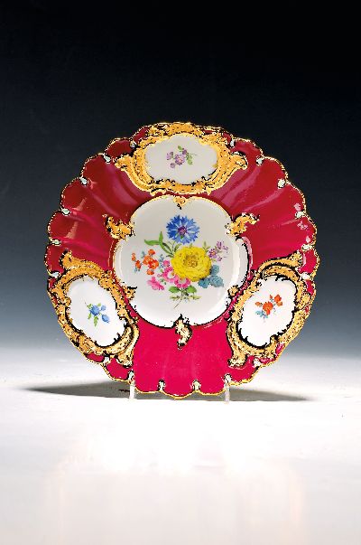 Prunkteller, Meissen, 1970er Jahre, 2. Wahl, partiell purpurrot glasiert, matt- und glanzvergoldetes Relief, bunte Blumenmalerei, D. ca. 23.5cm