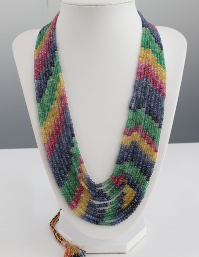 Farbstein-Collier, wohl Indien, 9-rhg., facett. Rubine, Smaragde und Saphire in versch. Farben, verlaufend, L. durch Seidenkordel variabel bis 108 cm