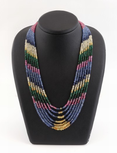 Farbstein-Collier, wohl Indien, 7-rhg., facett. Rubine, Smaragde und Saphire in versch. Farben, verlaufend, L. variabel durch Seidenkordel 45-94 cm