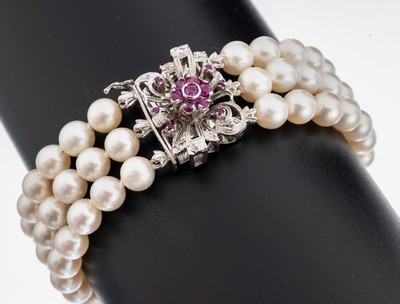 18 kt Gold Perl-Diamant-Rubin-Armband, WG 750/000, 3-rhg. Akoyazuchtperlen, D. ca. 6-6.3mm, Stege mit 4 8/8-Diamanten, 13 rundfacett. Rubine zus. ...
