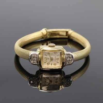 Damenarmbanduhr in GG 585/000 mit Diamanten, Schweiz um 1960, Handaufzug, 2-teil. Geh. mit Diamantbesatz an den Bandanst., Boden aufgedr., silb. ...