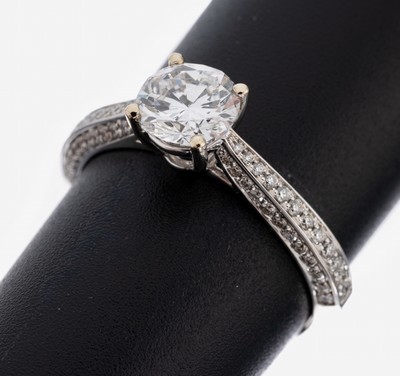 18 kt Gold Brillant-Ring, WG 750/000, mittig Brillant ca. 1.00 ct hochfeines Weiß+(D)/vvs1, Ringschultern mit Brillanten zus. ca. 0.36 ct feines ...