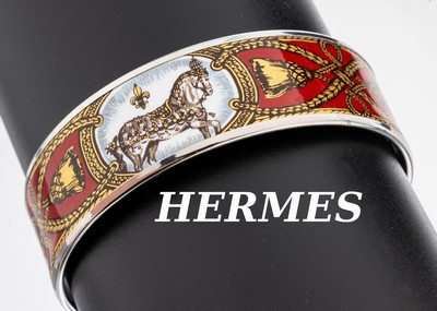 HERMES Email-Armreif, Metall, rotgrundig emaill., umlaufendes Motiv mit Pferden, goldfarb. Quasten und Bändern, sign. HERMES Paris, D. ca. 6.2 cm