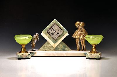 Tischuhr mit zwei Beistellern, Frankreich, 1930er Jahre, nach einem Entwurf von Chiparus, bicolores Marmorgehäuse mit Metallfiguren, Kinderpaar und ...