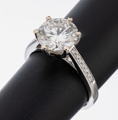 18 kt Gold Brillant-Ring, WG 750/000, mittig Brillant ca. 3.06 ct Weiß(H)/si2, Ringschultern mit Brillanten zus. ca. 0.13 ct (grav.) Weiß/vs-si, ...