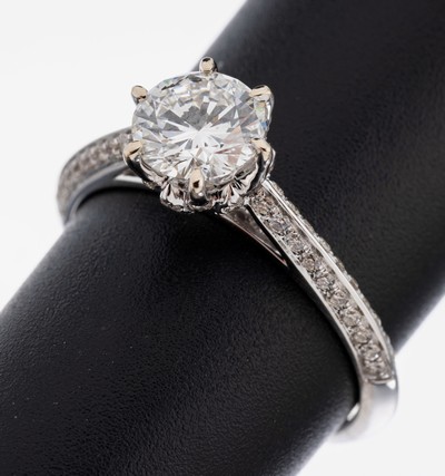 18 kt Gold Brillant-Ring, WG 750/000, mittig Brillant ca. 1.01 ct hochfeines Weiß(E)/vs1, weitere Brillanten zus. ca. 0.44 ct (grav.) feines ...