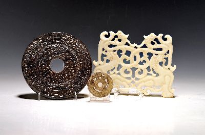3 Teile Schnitzereien, China, 20. Jh., 1) weiße Jade, Fabeltiere geschnitzt in Durchbrucharbeit, ca. 13x18cm; 2) rund, in Form eines Winddrachen, ...