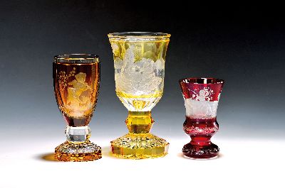 Drei Pokale, wohl bay. Wald/Böhmen, Anfang 20. Jh., Kristallglas, fein geschnitten, 1. umlaufende Jagdszene, z.T. gelb gebeizt, H. ca. 21.5 cm; 2. ...