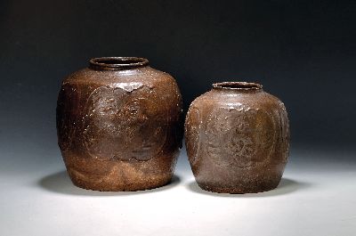 2 Vorratsgefäße, China, 19. Jh., Steinzeug, reliefierter Dekor von Blumen in Kartuschen, dunkelbraune Glasur, H. ca. 28 bzw. 35cm