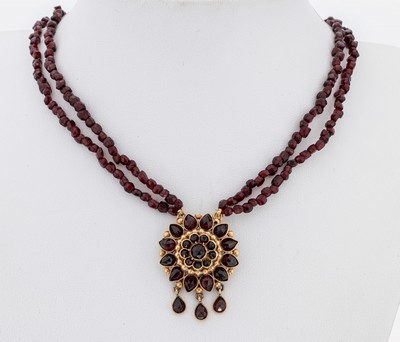 Granat-Collier mit 8 kt Gold Mittelteil, um 1880-1900, GG 333/000 gepr., 2 2-rhg. Kettenstränge aus facett. Granaten, blütenf. Mittelteil mit 3 ...