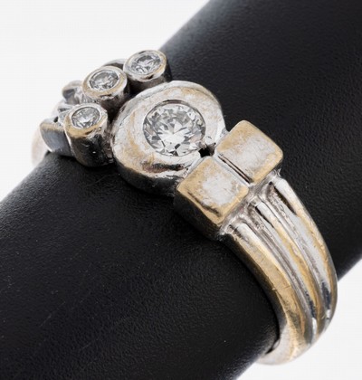 18 kt Gold Brillant-Ring, WG 750/000, ausgefallene Ringschiene, Brillant ca. 0.25 ctfeines Weiß/vs, seitl. 3 Brillanten zus. ca. 0.09 ct feines ...