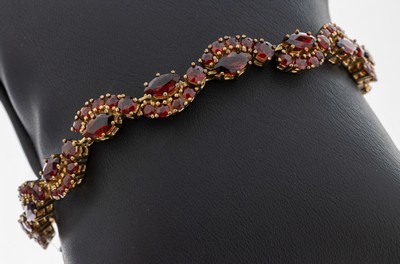 8 kt Gold Granat-Armband, GG 333/000, geschwungenes Design, rundfacett. Granate und Granat-Navettes, L. ca. 18.5 cm, Kastenschlossmit ...