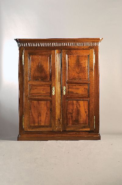 Schrank, wohl Freiburg, um 1800, Nußbaum, zweitürig, mehrfach kassettiert, Schellack poliert, Zahnfrieß, feine Kanneluren, Messingbeschläge, ca. ...