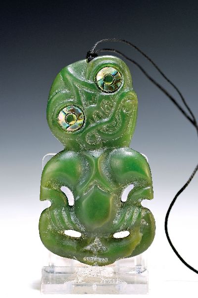 Hei Tiki, Amulett der Maori, Neuseeland, Nephrit sog. Greenstone, geschnitzt und geritzt, Augen mit Perlmutteinlagen, 8x4,5 cm, mit Lederband