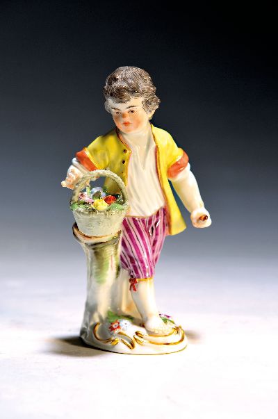Porzellanfigur, Meissen, 20. Jh., Knabe mit Korb, bunt bemalt, Goldstaffage, H. ca. 12.5 cm, min. an den Blättern best.