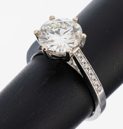 18 kt Gold Brillant-Ring, WG 750/000, mittig Brillant ca. 3.04 ct l.get.Weiß(J)/si1,Ringschultern mit 14 Brillanten zus. ca. 0.16 ct (grav.) feines ...