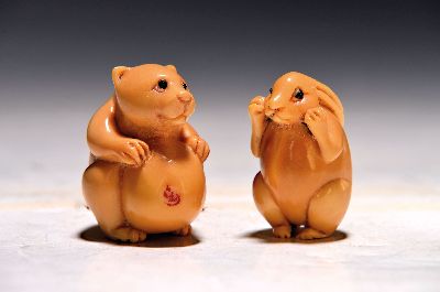 Zwei Netsuke aus Tagua-Nuss, Japan, späte Meiji-Zeit, Tagua-Nuss sog. Pflanzen -Elfenbein geschnitzt, Hase und Bär, jeweils mit Ritzsignatur, H. 5 ...