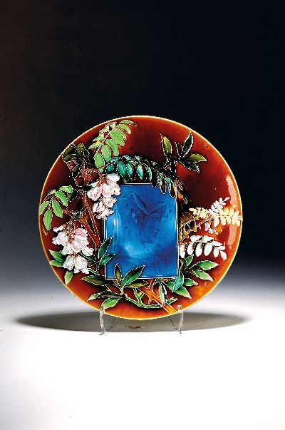 Großer Wandteller, Villeroy & Boch, um 1900,Feinsteingut, auf dem Rand reliefierter und bunt bemalter Glyziniendekor, mittig geritztes Porträt ...