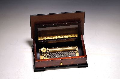 Walzenspieluhr, Reuge, Schweiz, 20. Jh.,, Kammin gutem Zustand, Nussbaumgehäuse, furniert, mattiert, Deckel mit Einlagen, ca. 23 x13.5 cm, drei ...