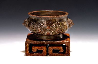 kleines Räuchergefäß, China, um 1900, Bronze, umlaufender Drachendekor, dazu geschnitzter Holzsockel (später), D. ca. 11.5 cm, H. ca. 5.5 cm, mit ...
