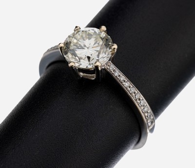 18 kt Gold Brillant-Ring, WG 750/000, mittig Brillant ca. 1.58 ct get.Weiß/si, Steinsollte nachgefasst werden, Ringschultern mit Brillanten zus. ...