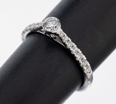 18 kt Gold Brillant-Ring, WG 750/000, 1 Brillant ca. 0.25 ct feines Weiß/si, 6 Brillanten zus. ca. 0.11 ct feines Weiß/si, 8 Brillanten zus. ca. ...
