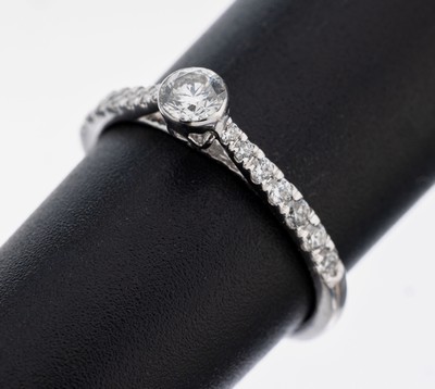 18 kt Gold Brillant-Ring, WG 750/000, 1 Brillant ca. 0.25 ct feines Weiß/si, 6 Brillanten zus. ca. 0.11 ct feines Weiß/si, 8 Brillanten zus. ca. ...