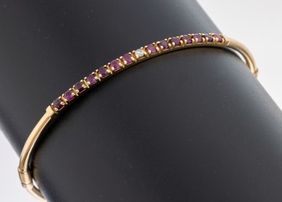 14 kt Gold Rubin-Brillant-Armreif, GG 585/000 gepr., 14 rundfacett. Rubine zus. ca. 0.30 ct, 1 Brillant ca. 0.02 ct Braun/p, D. ca. 5.7 x 5.1 cm, ...