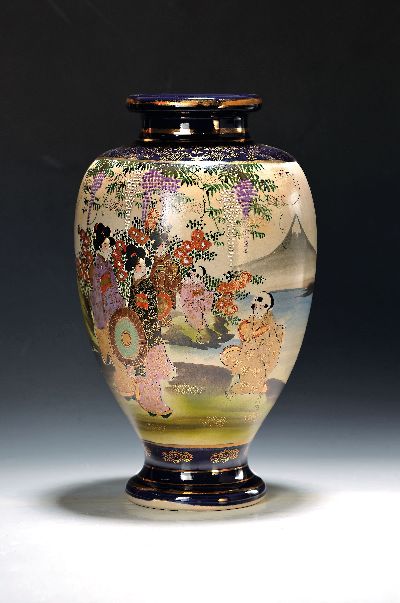 Vase, Japan, 1930er Jahre, Satsuma, partiell kobaltblau glasiert mit Golddekor, in Kartuschen bunt bemalt mit Personen im Garten, H. ca. 37cm